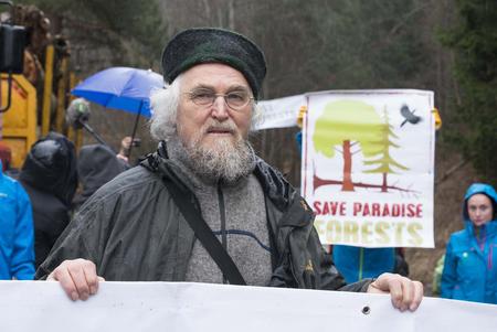 Der deutsche Wissenschaftler Professor Dr. Hannes D. Knapp mit Aktivisten und Plakaten vor einer Forstmaschine