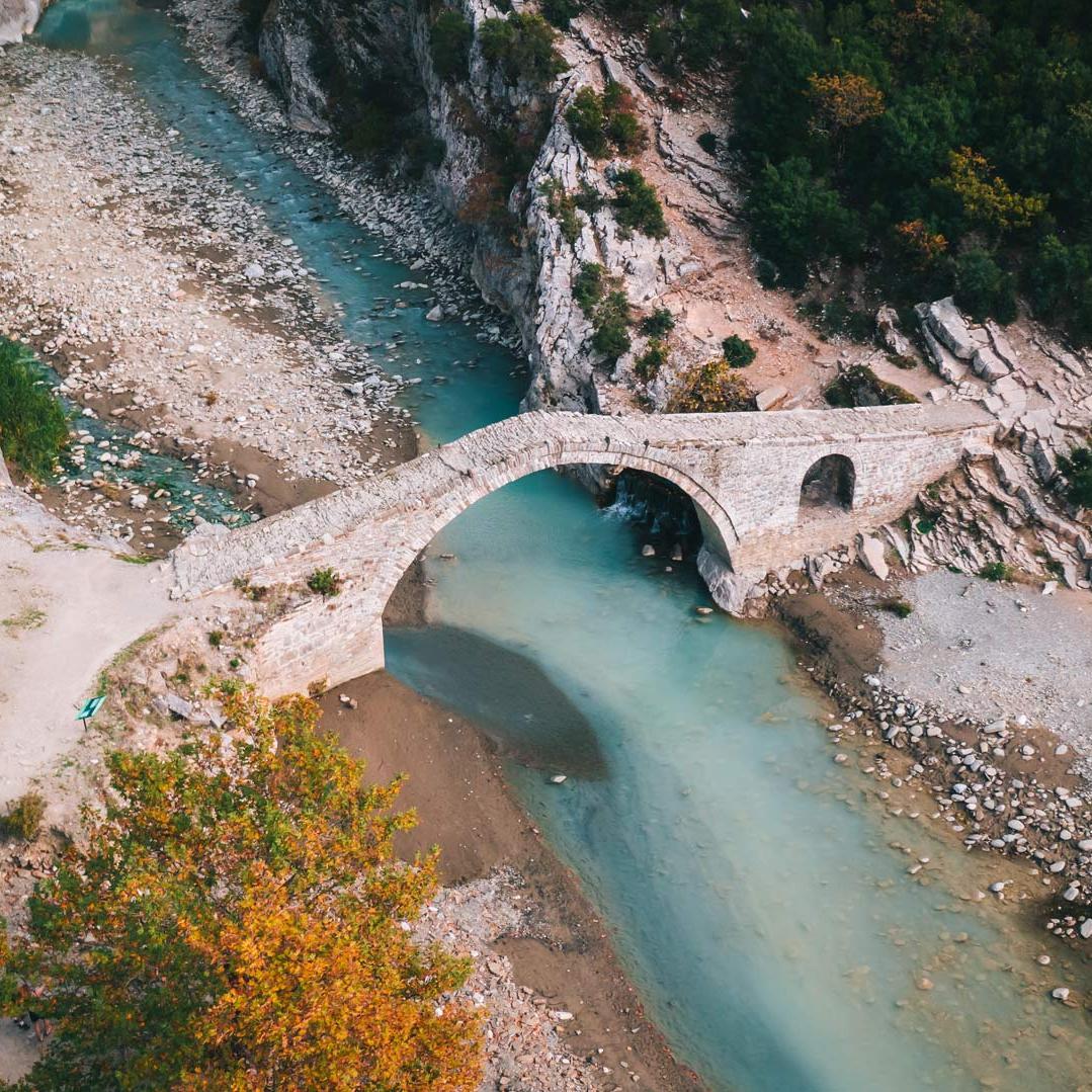 Aerial view of the Vjosa River with the old Ottoman bridge, Langarica in Albania