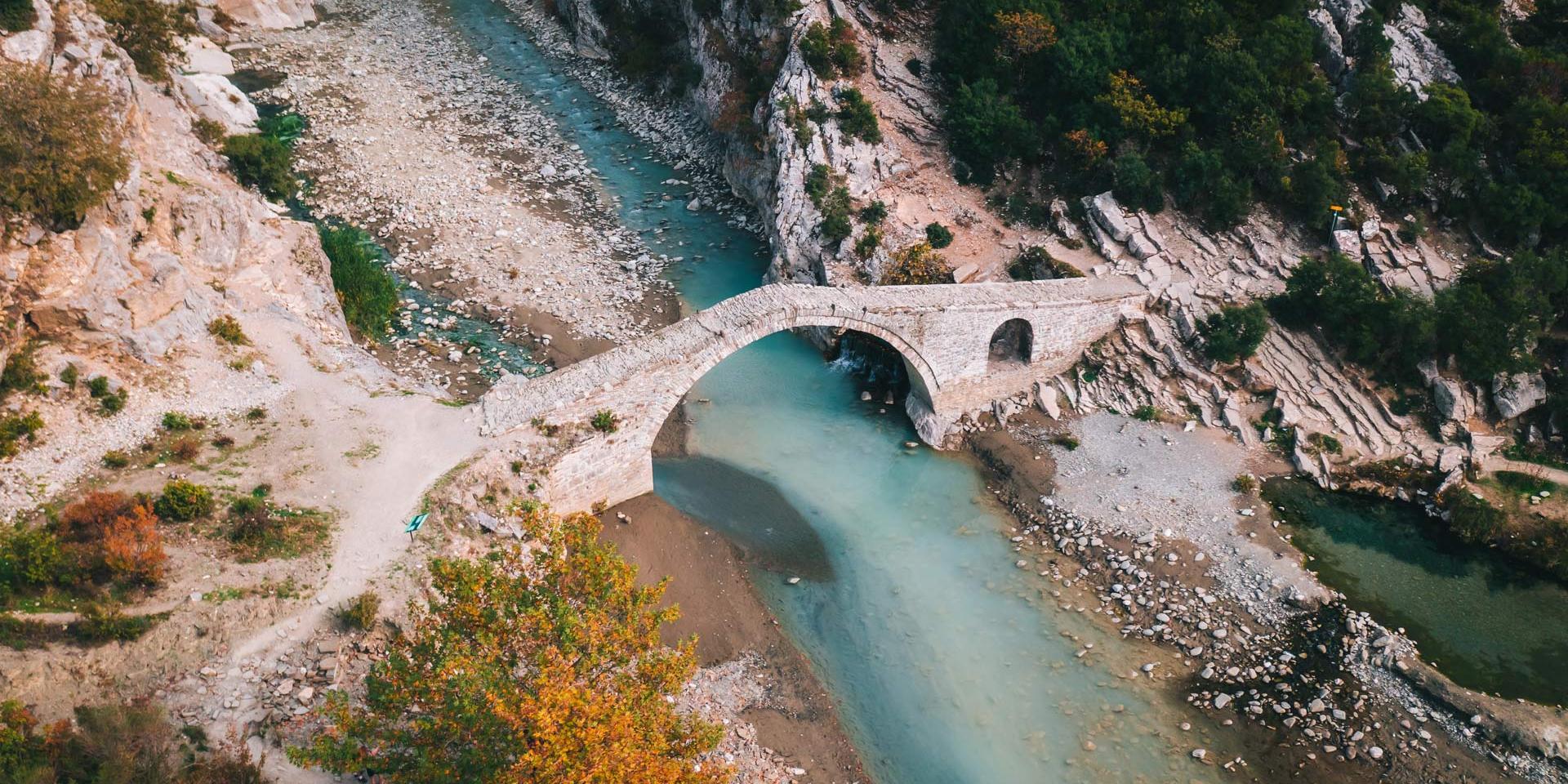 Luftaufnahme vom Fluss Vjosa mit der alten osmanischen Brücke, Langarica in Albanien