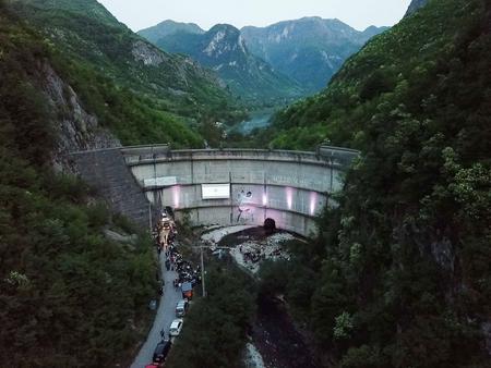 Blick auf den Idbar Staudamm an dem eine Kinoleinwand hängt