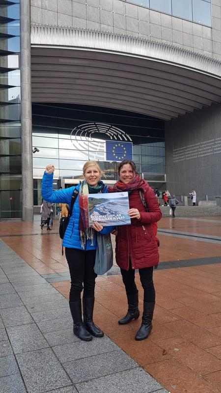 Two women in front of the EU Parliament holding a picture of Vjosa.